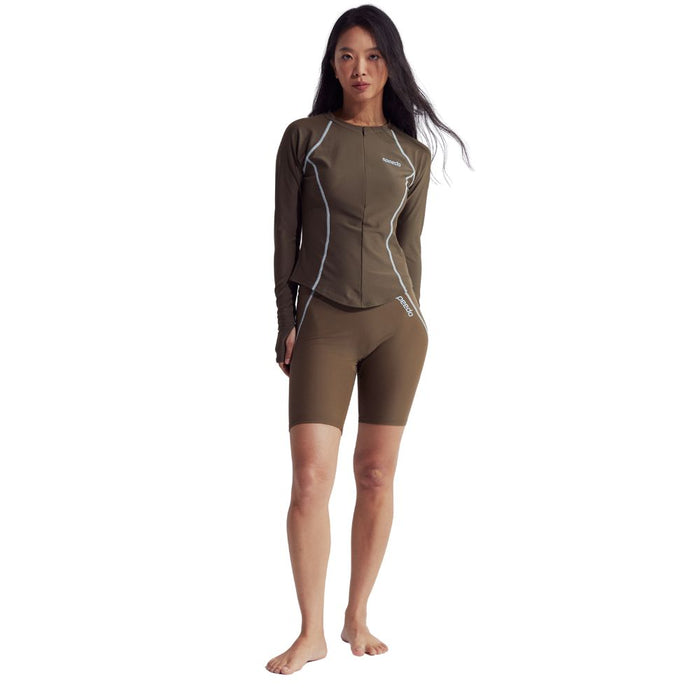 Woman in a brown Speedo Wavechasers 2.0 shaping rashguard with white piping and zipper.
